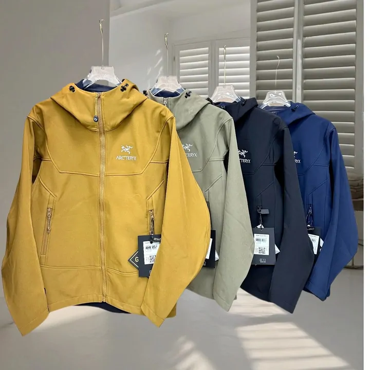 Rack of hooded technical shell jackets in yellow, olive and navy with tags attached