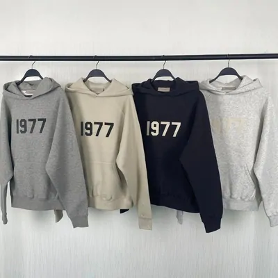 Four 1977-print hoodies in grey, oatmeal, navy and pale grey on hangers