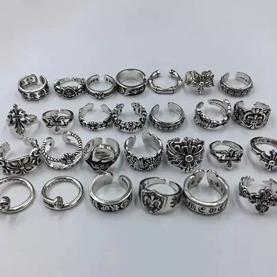 Dozens of chunky silver rings with cross and skull engravings on white